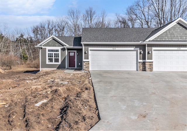 view of front of home featuring stone siding, driveway, an attached garage, and board and batten siding