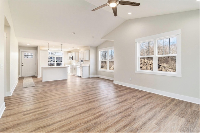 unfurnished living room with baseboards, lofted ceiling, recessed lighting, light wood-style flooring, and a ceiling fan