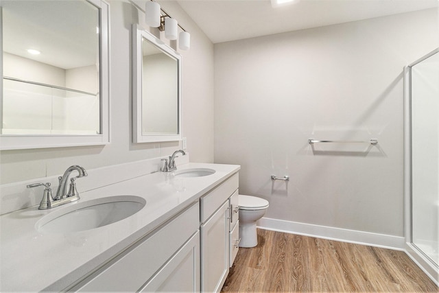 full bathroom with wood finished floors, baseboards, a shower with door, and a sink