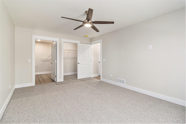 unfurnished bedroom featuring visible vents, carpet flooring, ensuite bathroom, and baseboards