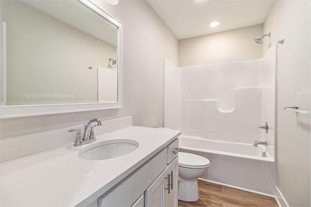 full bathroom with shower / bathtub combination, toilet, wood finished floors, and vanity