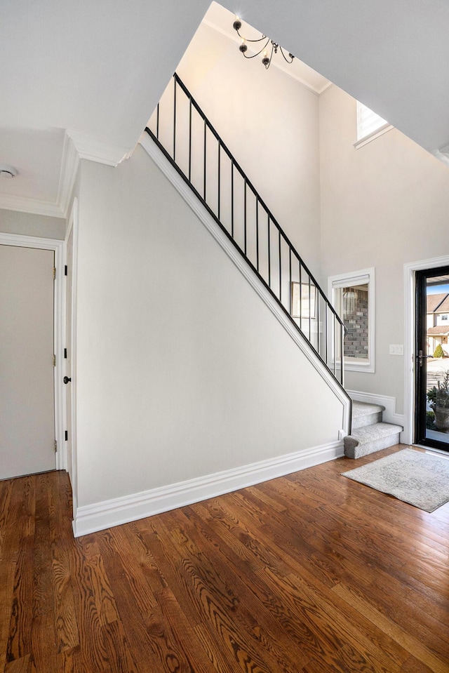 foyer entrance featuring stairway, ornamental molding, baseboards, and wood finished floors