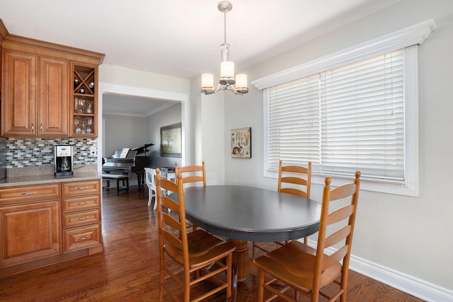 dining room featuring a notable chandelier, dark wood-style floors, and baseboards