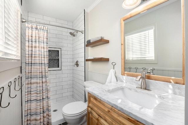 full bath with a wainscoted wall, toilet, a stall shower, ornamental molding, and vanity