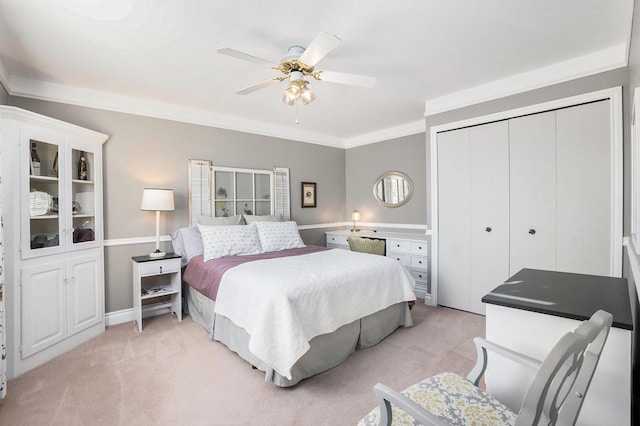 bedroom with ceiling fan, crown molding, a closet, and light carpet