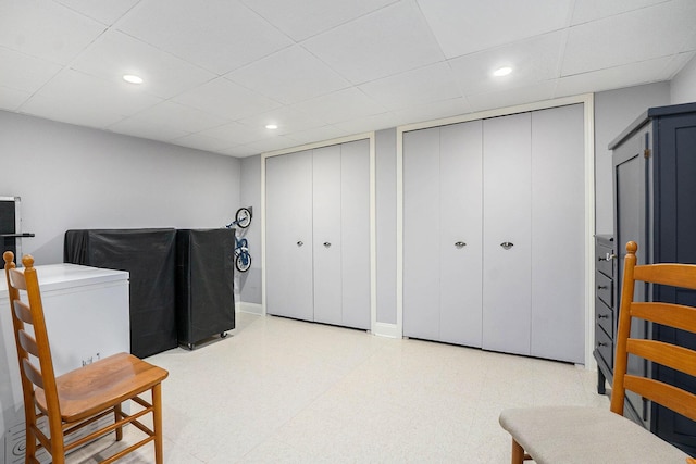 living area with tile patterned floors, a drop ceiling, and recessed lighting