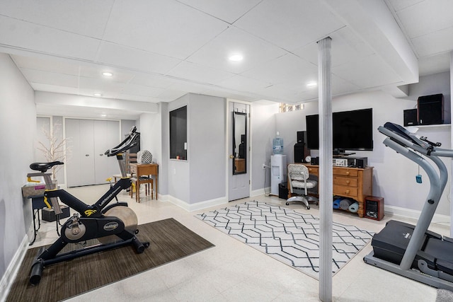 exercise area with tile patterned floors, recessed lighting, a paneled ceiling, and baseboards