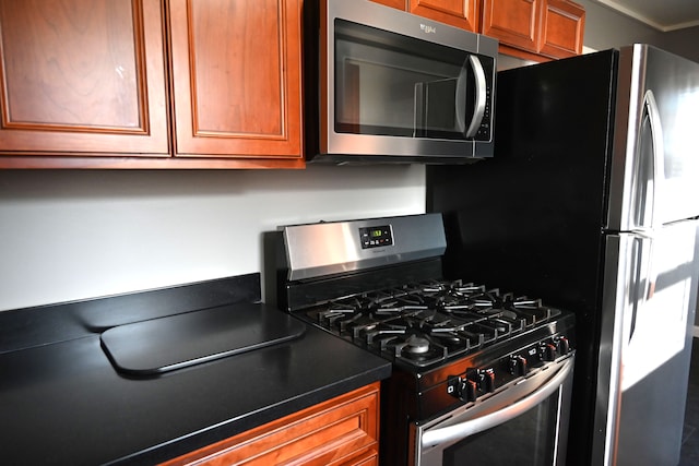 kitchen with dark countertops, brown cabinets, and appliances with stainless steel finishes