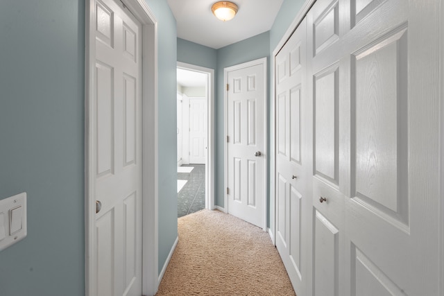 hall with baseboards and carpet floors