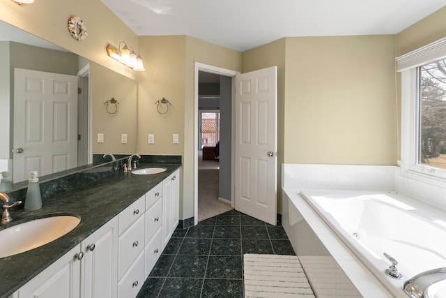 bathroom with tile patterned flooring, double vanity, a relaxing tiled tub, and a sink