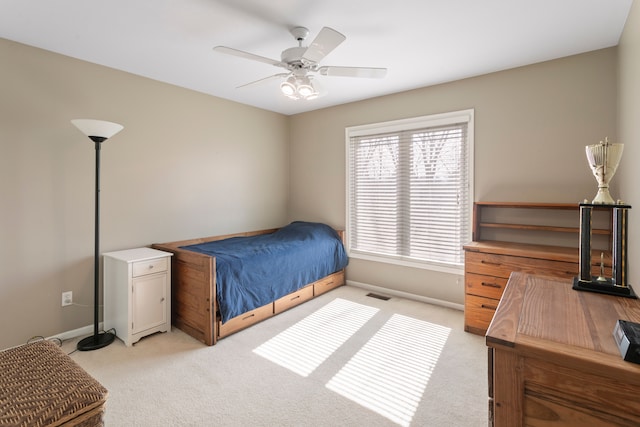 bedroom featuring visible vents, baseboards, light colored carpet, and ceiling fan