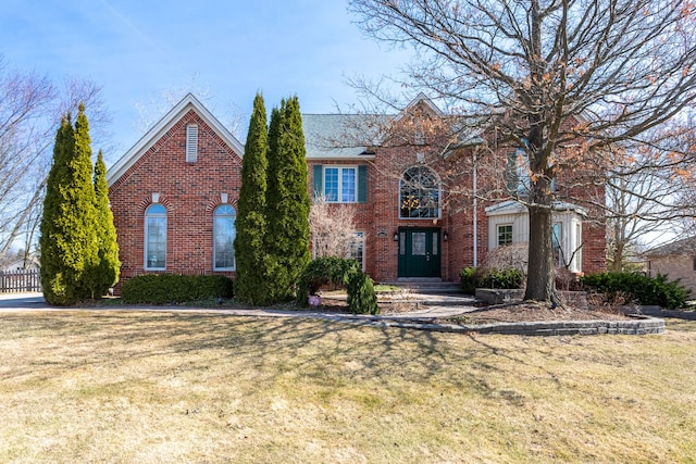 view of front of house with brick siding and a front yard