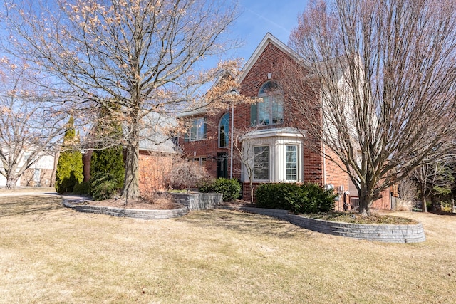 view of front of home with a front yard and brick siding