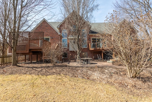 back of house featuring a patio, fence, brick siding, and a wooden deck