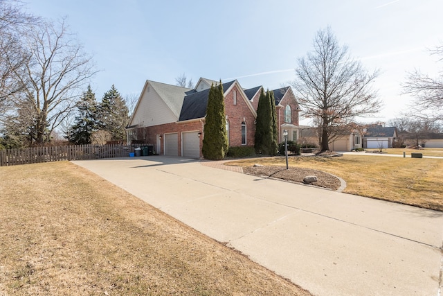 traditional-style home featuring fence, driveway, an attached garage, a front lawn, and brick siding