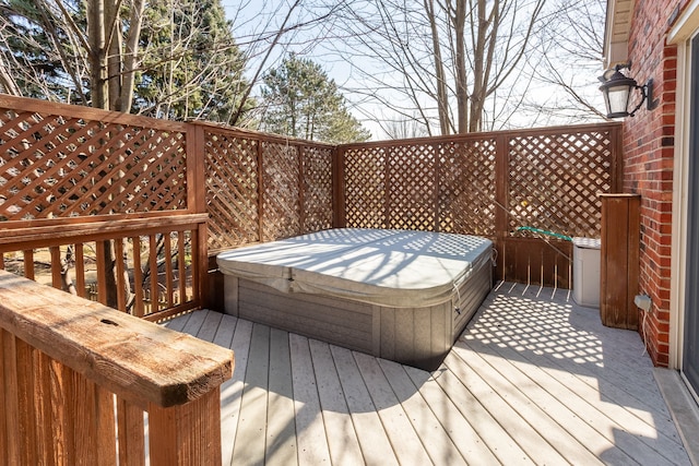 wooden deck featuring a covered hot tub