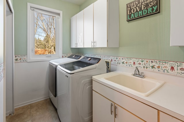 clothes washing area with light tile patterned floors, baseboards, cabinet space, a sink, and washing machine and dryer