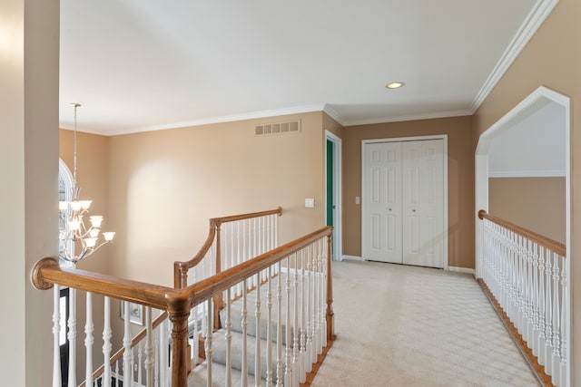 hall featuring visible vents, an upstairs landing, carpet floors, and a chandelier