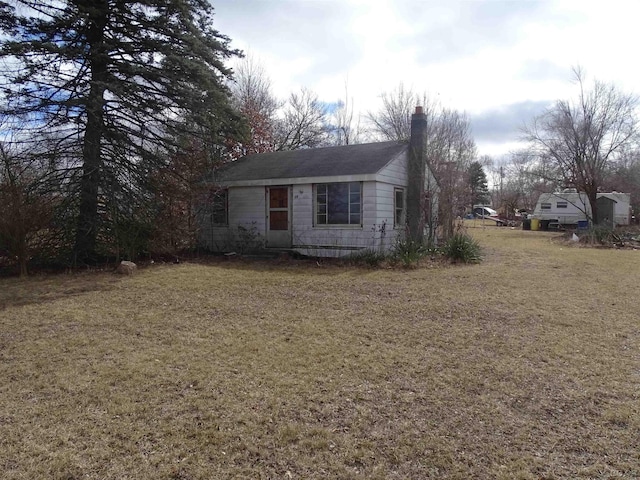 view of front of property featuring a chimney and a front yard