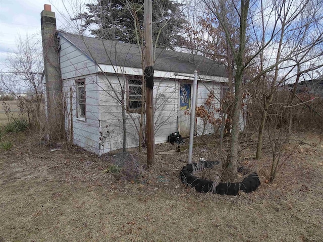 view of home's exterior featuring a chimney and a shingled roof