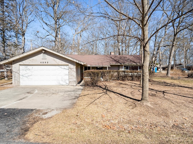 ranch-style house featuring a garage and concrete driveway