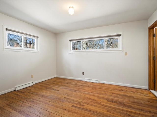 unfurnished room with visible vents, baseboards, light wood finished floors, and a baseboard radiator