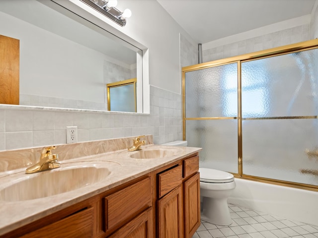 full bathroom with a sink, tile walls, double vanity, and tile patterned flooring