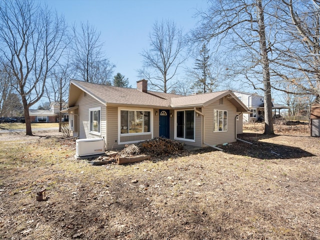 view of front of home featuring a chimney and roof with shingles