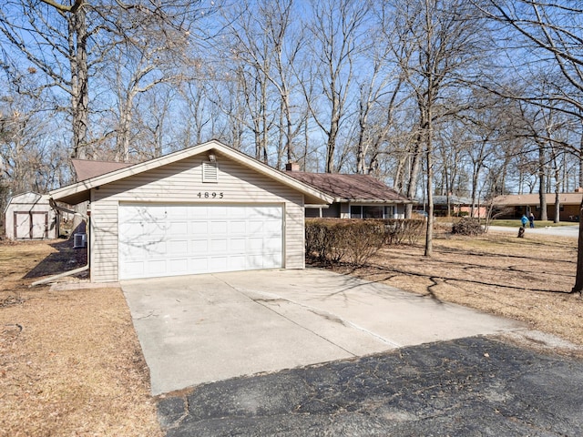 view of side of property with concrete driveway and a garage