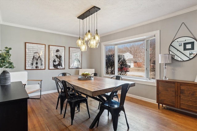 dining area featuring ornamental molding, baseboards, and wood finished floors