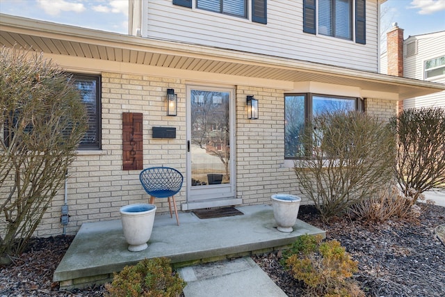 doorway to property featuring brick siding