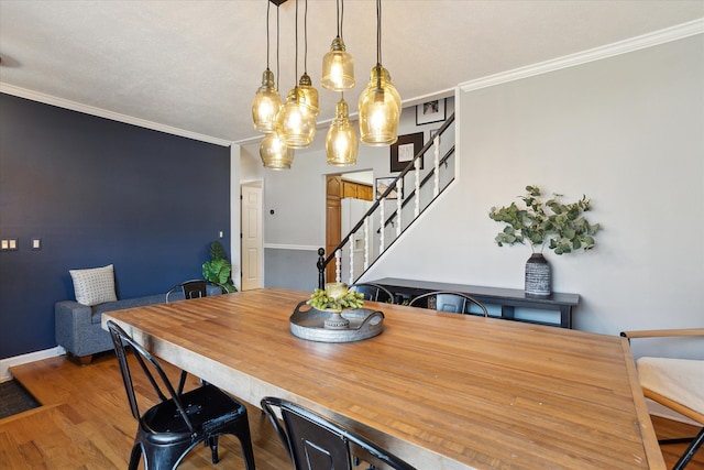 dining area featuring stairway, wood finished floors, baseboards, an inviting chandelier, and ornamental molding