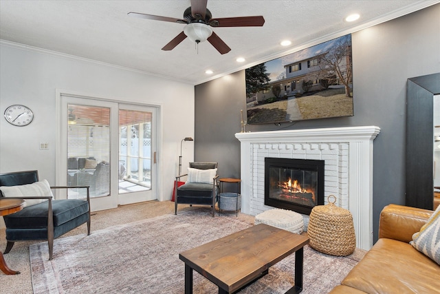 carpeted living area with recessed lighting, a brick fireplace, crown molding, and ceiling fan