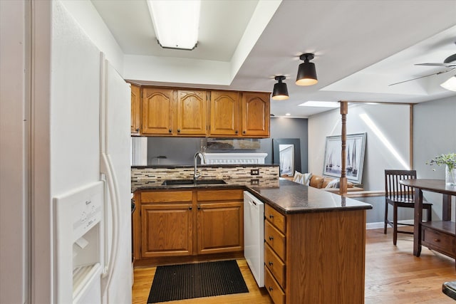 kitchen with brown cabinets, a peninsula, and a sink