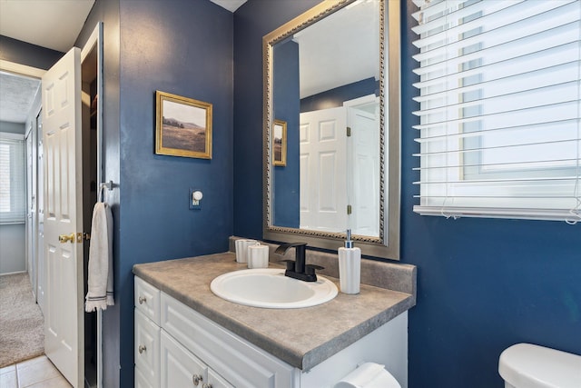 half bath with tile patterned floors, toilet, and vanity