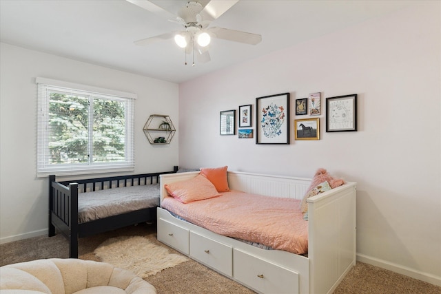 bedroom featuring light colored carpet, a ceiling fan, and baseboards