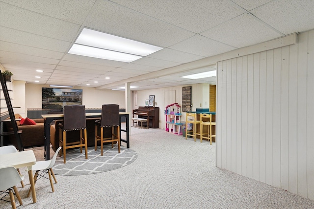 rec room with a paneled ceiling, a dry bar, and carpet flooring