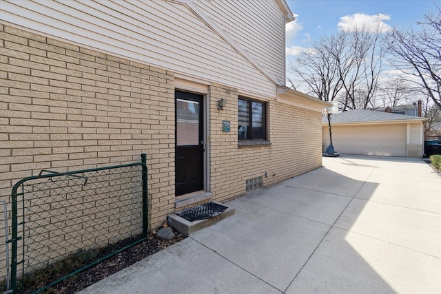 doorway to property with a garage, brick siding, and crawl space