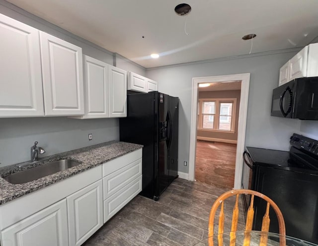 kitchen with black appliances, baseboards, dark stone countertops, white cabinetry, and a sink