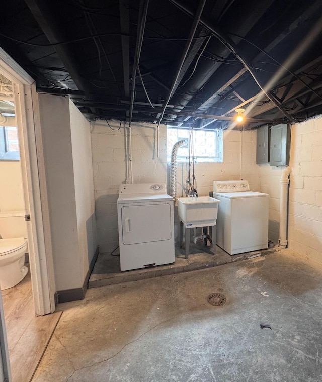 basement featuring a sink, electric panel, and washing machine and dryer