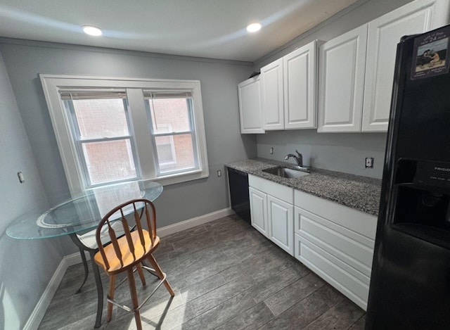 kitchen featuring black appliances, a sink, dark wood finished floors, white cabinets, and baseboards