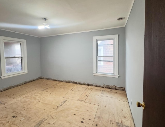 spare room with visible vents and crown molding