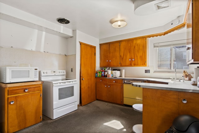 kitchen featuring visible vents, light countertops, brown cabinets, white appliances, and a sink