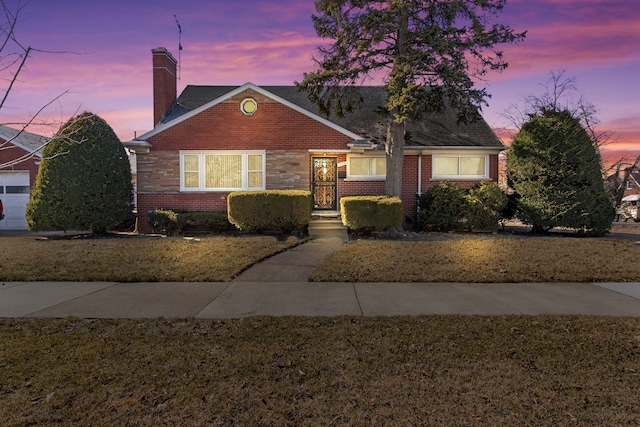 view of front of home featuring brick siding and a chimney