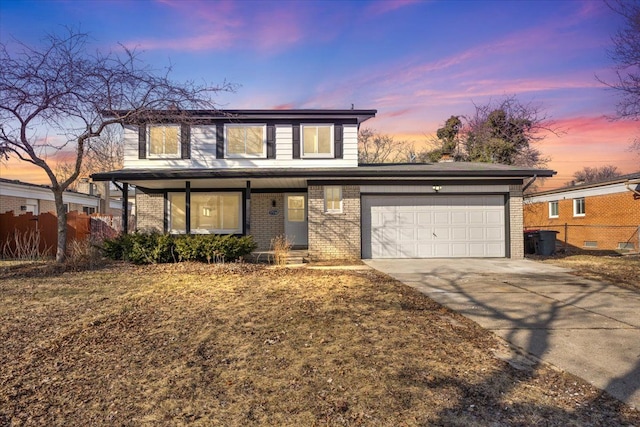 traditional-style home with fence, covered porch, concrete driveway, a garage, and brick siding