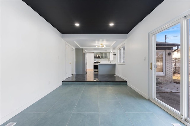 hall featuring recessed lighting, baseboards, a raised ceiling, and tile patterned flooring