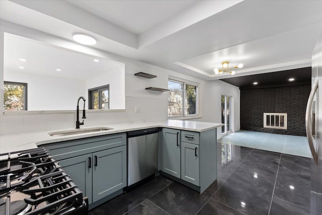 kitchen featuring a sink, dishwasher, a peninsula, and gray cabinetry