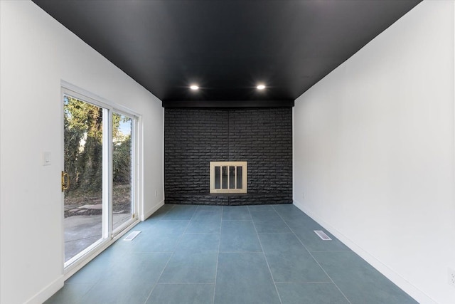 empty room with recessed lighting, baseboards, a fireplace, and tile patterned flooring