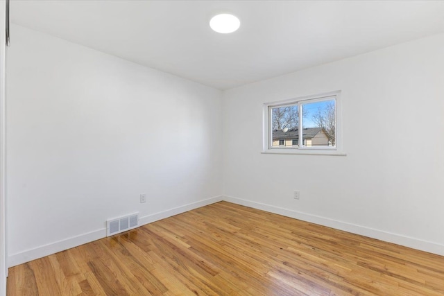 spare room with visible vents, baseboards, and light wood-style floors