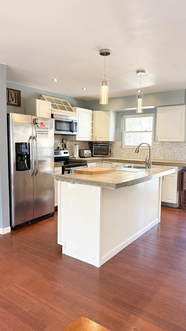 kitchen with white cabinetry, dark wood-style floors, a kitchen island with sink, and appliances with stainless steel finishes